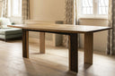 Custom oak dining table with acid-forged metal feet by Junto